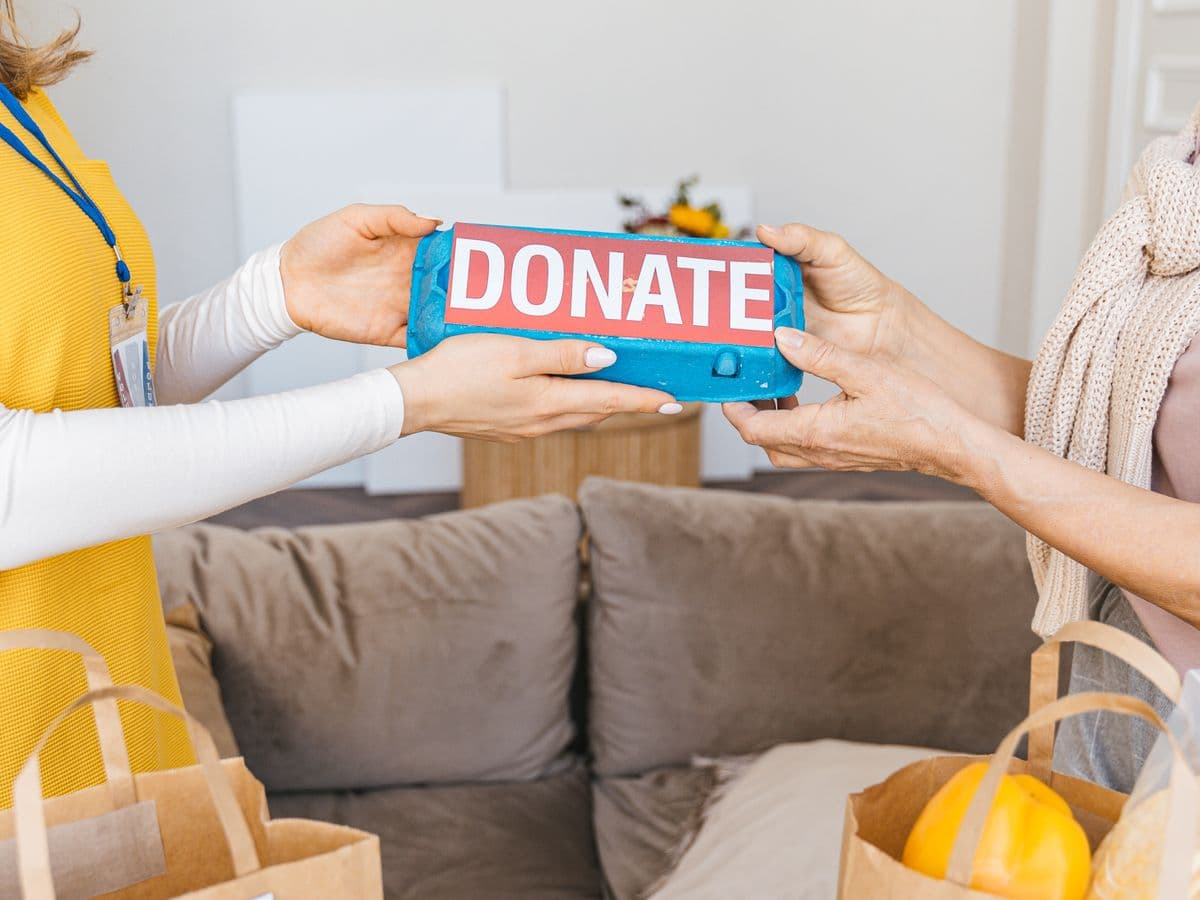 Two people passing a box of donated food between them